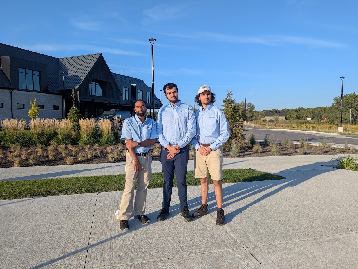 Three members of the STELLAR Media team standing together outdoors in branded shirts